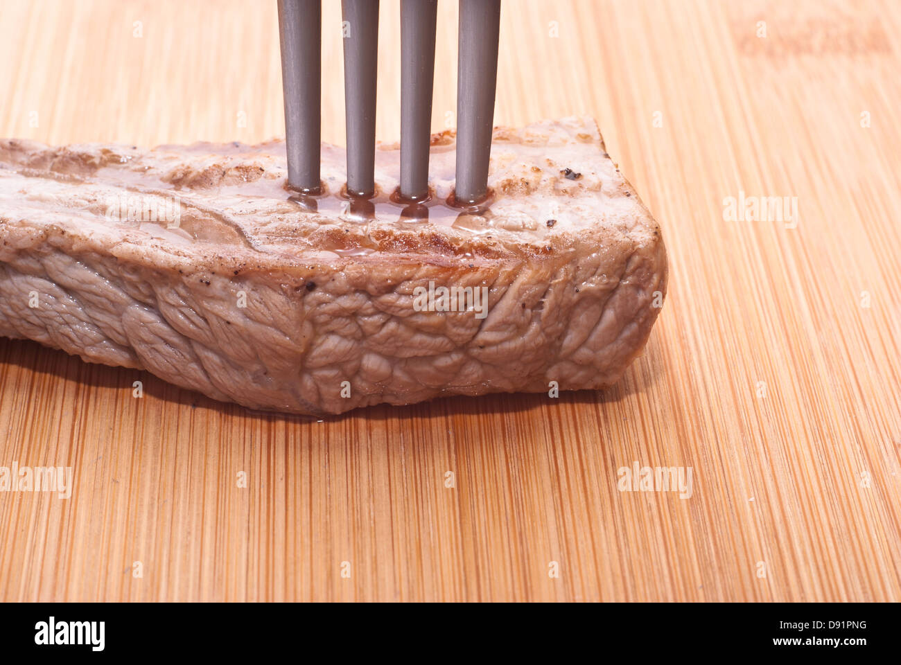 Rindfleisch mit Gabel auf einem hölzernen Hintergrund Stockfoto