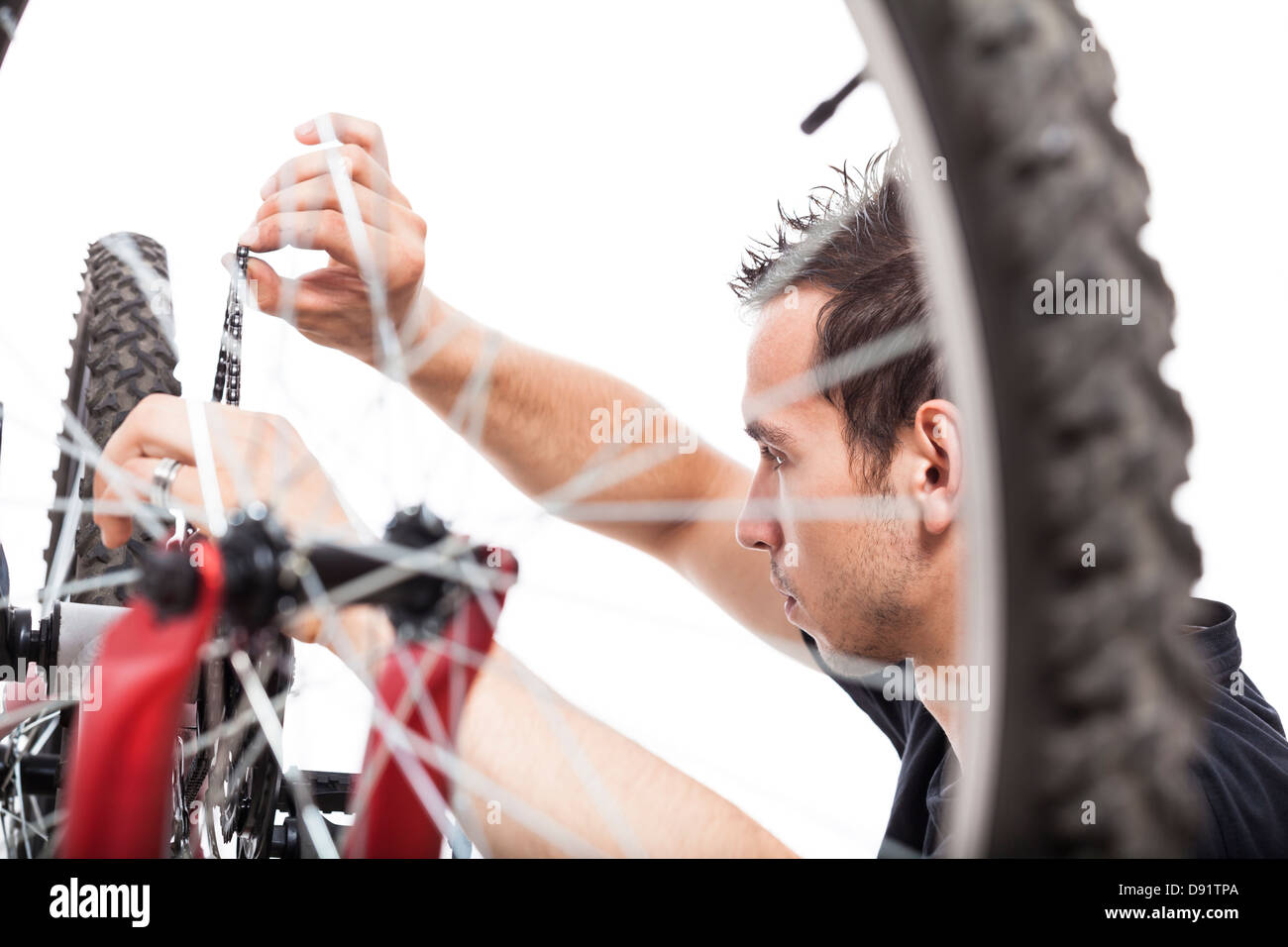 Junger Mann Anpassung Fahrradkette und Reparatur Fahrrad, isoliert auf weißem Hintergrund Stockfoto