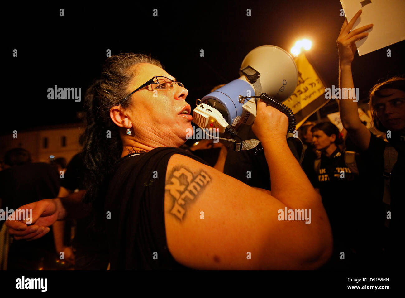 Eine Demonstrantin mit einem hebräischen Schriftstück in ihrem Arm, das "nicht Nizza" lautet, ruft bei einer Kundgebung gegen eine umstrittene Vereinbarung zwischen der Regierung und großen Energieunternehmen über die Erdgasproduktion, West-Jerusalem Israel, gegen Netanjahu-Slogans Stockfoto