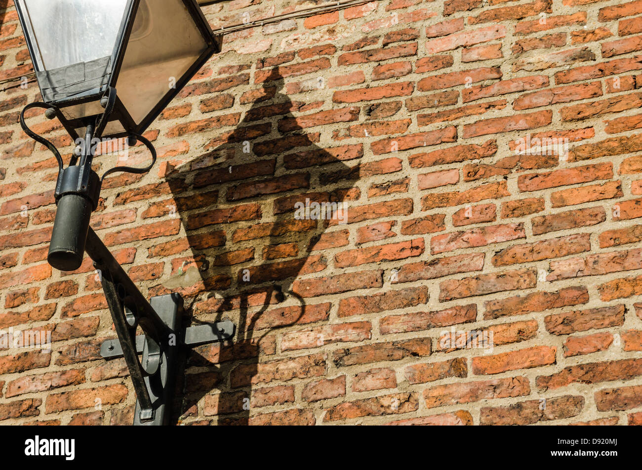 Lampe wirft einen Schatten auf einer roten Backsteinmauer. York, North Yorkshire, England. Stockfoto