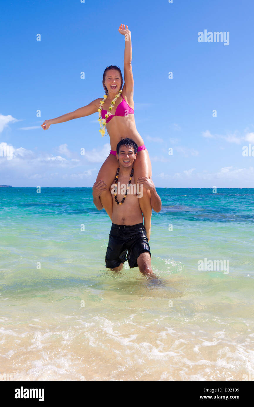 Gemischtes Paar spielen am Strand auf hawaii Stockfoto