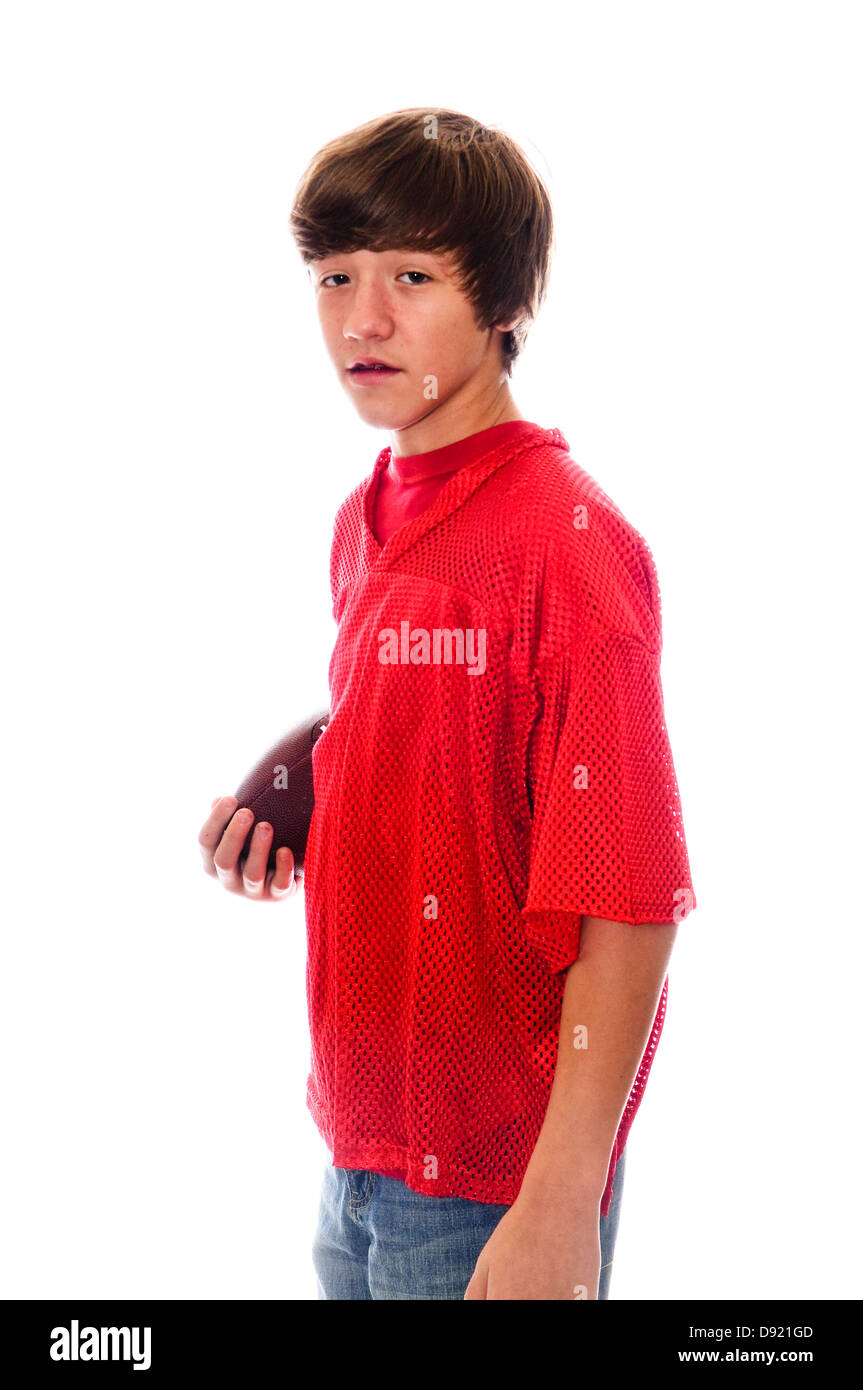 Junge Teen hält einen Fußball in roten Trikots isoliert auf weißem Hintergrund. Stockfoto