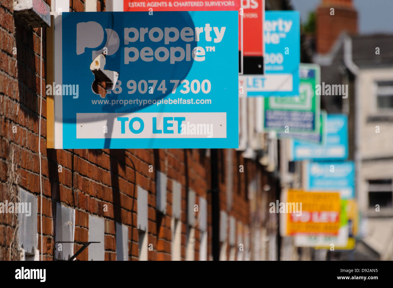 Häuserzeile mit vielen "zu verkaufen" und "lassen" Immobilienmakler Zeichen Stockfoto