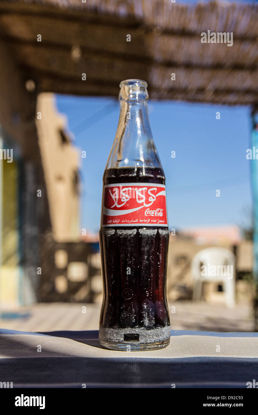 Eine Flasche Coca Cola in arabischer Schrift in einer Wüstenstadt in Merzouga, Marokko. Stockfoto