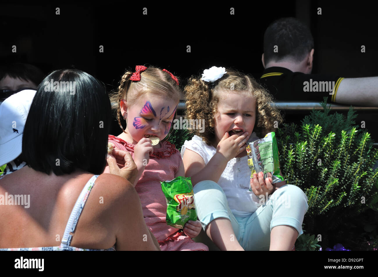 Westend Festival, Byres Road, Glasgow, Schottland, Großbritannien. 9. Juni 2013. Zwei junge Mädchen aus Paketen von Chips essen Stockfoto