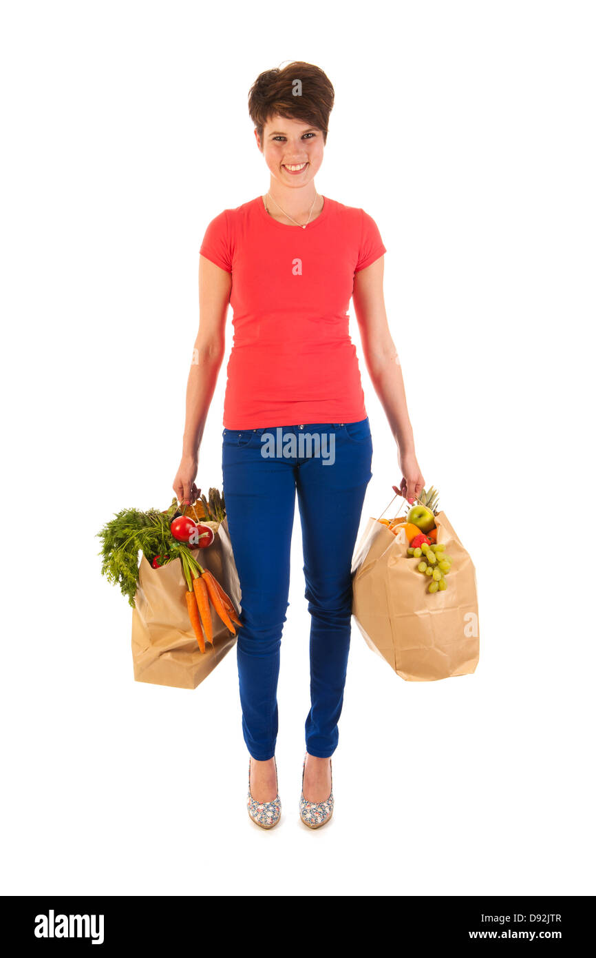 Hübsche junge Frau mit schweren Taschen gesundes Gemüse und Obst isoliert auf weißem Hintergrund Stockfoto