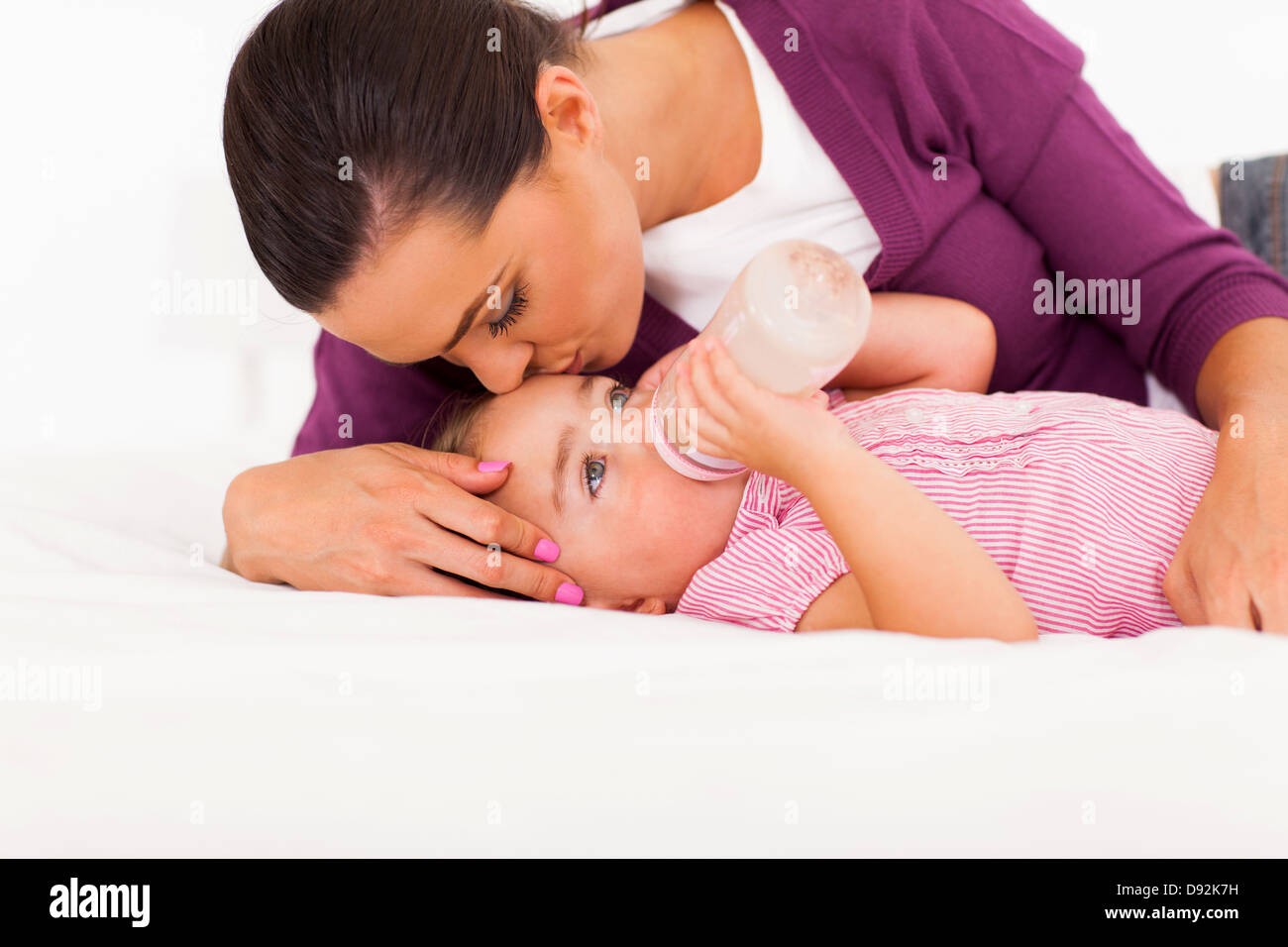 fürsorgliche Mutter Tochter während sie Trinkmilch küssen Stockfoto