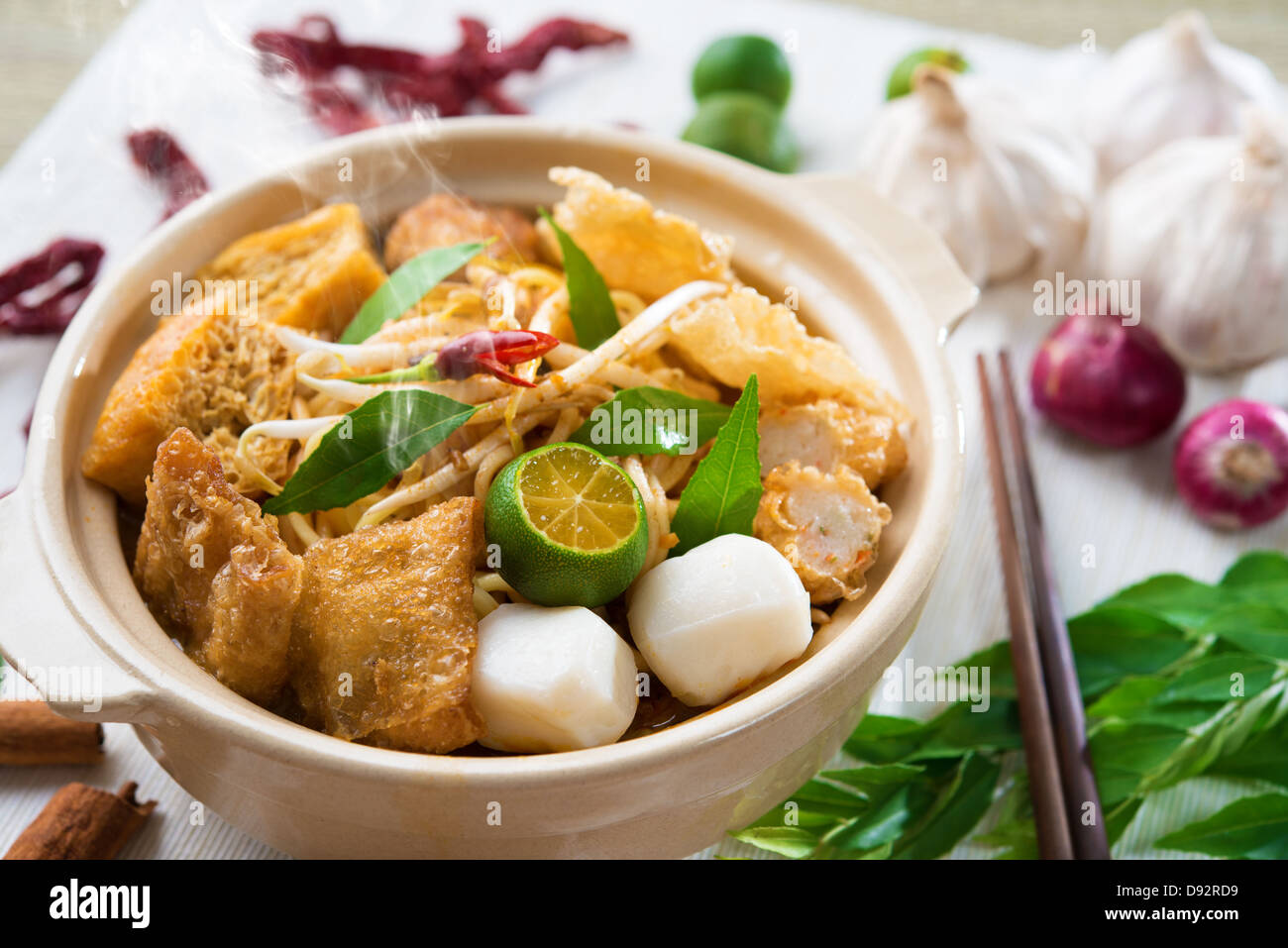 Scharf und würzig Singapur Curry Nudel Laksa mich mit heißem Wasserdampf im Tontopf, Dekoration Einrichtung dienen oder mit Stäbchen. Singapurischer Küche. Stockfoto