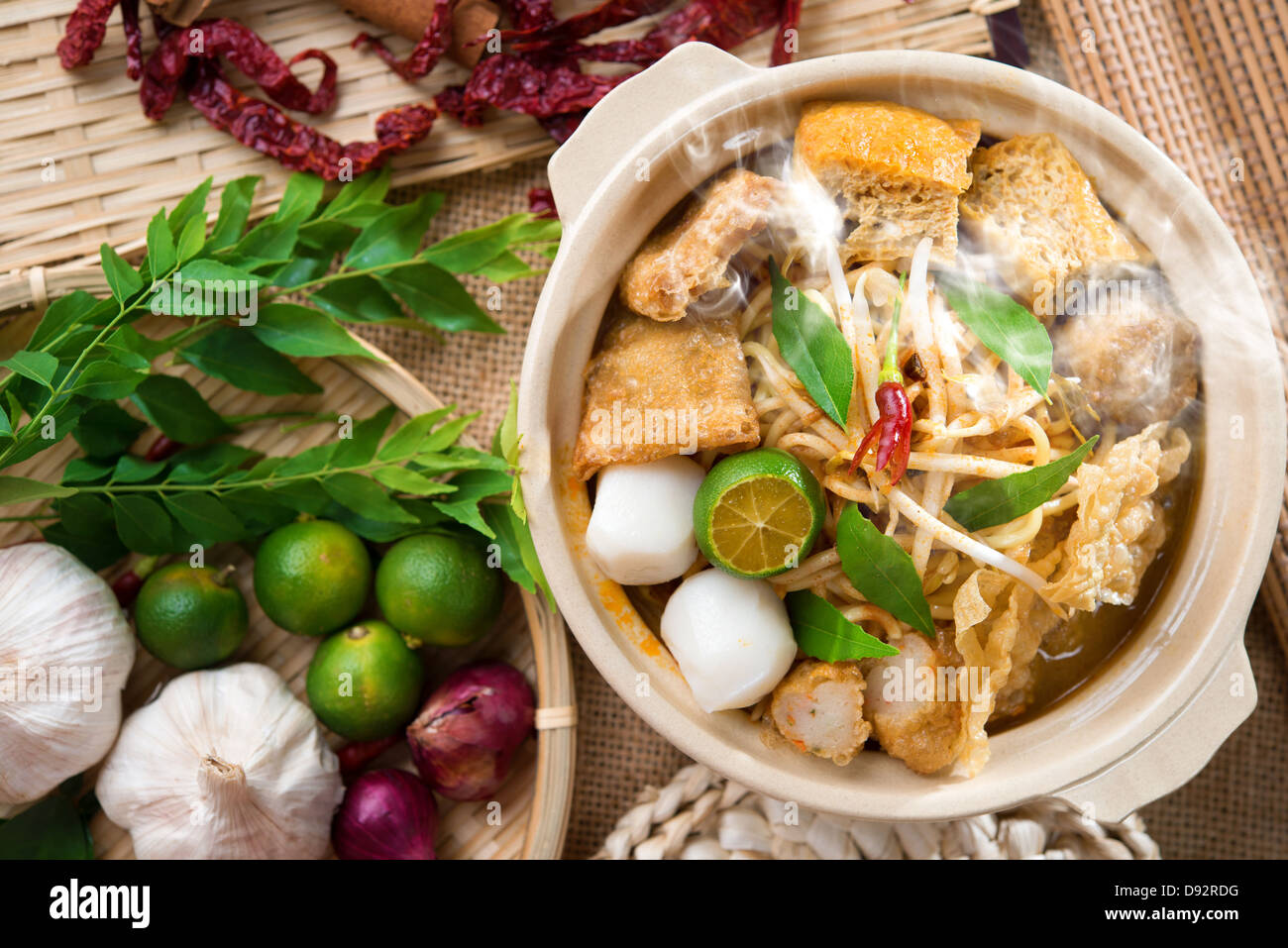 Scharf und würzig singapurischen Curry Nudel Laksa mich mit heißem Wasserdampf im Tontopf, Dekoration Einrichtung dienen oder mit Stäbchen. Singapur-Küche. Stockfoto
