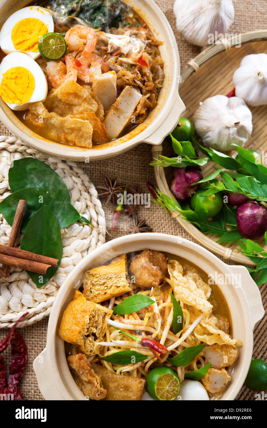 Scharf und würzig Curry Nudeln oder Laksa mich und Garnelen mit heißem Wasserdampf im Tontopf, Dekoration Einrichtung, Nudel servieren mit Stäbchen. Asia-Küche. Stockfoto