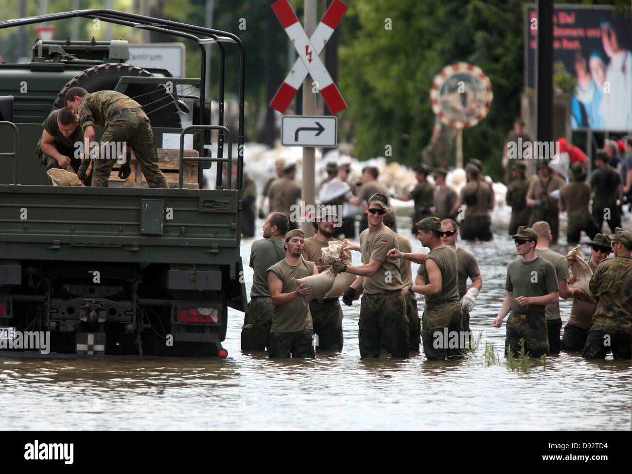 Soldaten der Bundeswehr bauen einen Damm durch die Anhäufung von Sandsäcken in einer Straße, die vom Wasser der Elbe in Magdeburg, Deutschland, 9. Juni 2013 überflutet. Die Hochwassersituation herrscht in den Bereichen an der Elbe. Foto: Jens Wolf Stockfoto