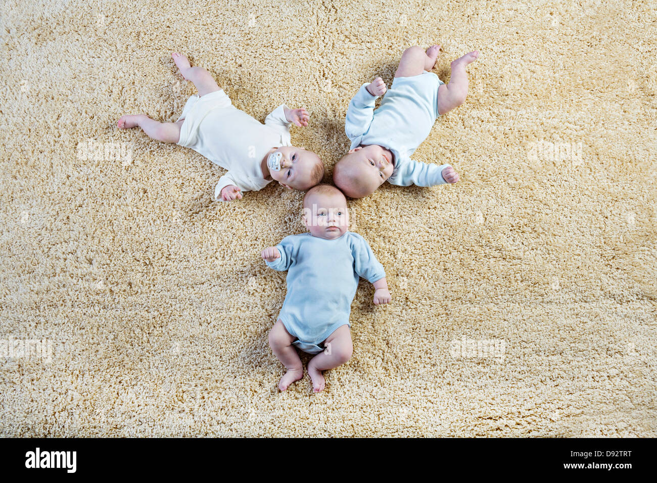 Bildung von drei Babys auf Teppich Verlegen Stockfoto