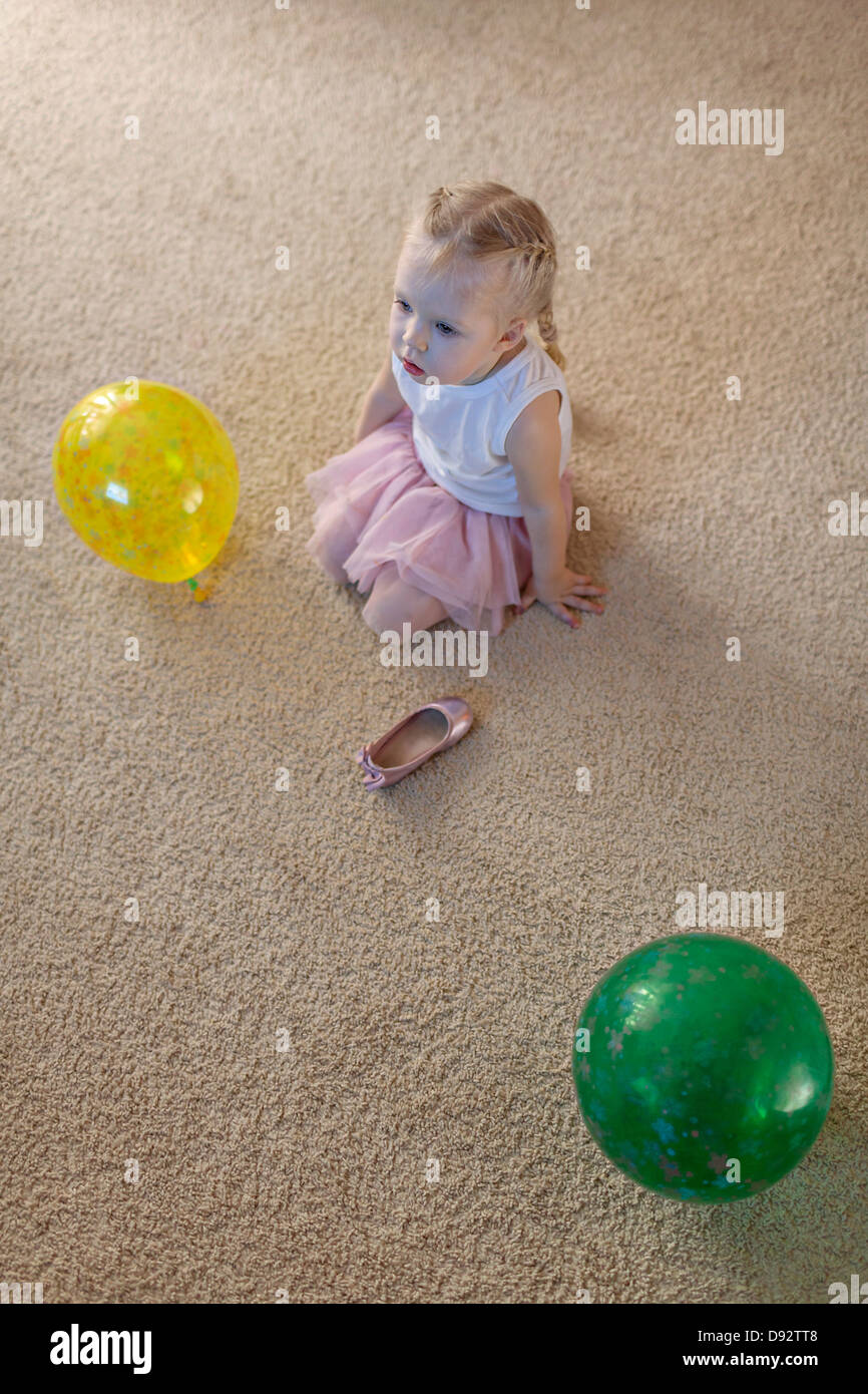 Kleines Mädchen zwischen zwei Ballons als ihrem Ballett Schuh liegt auf dem Boden Stockfoto