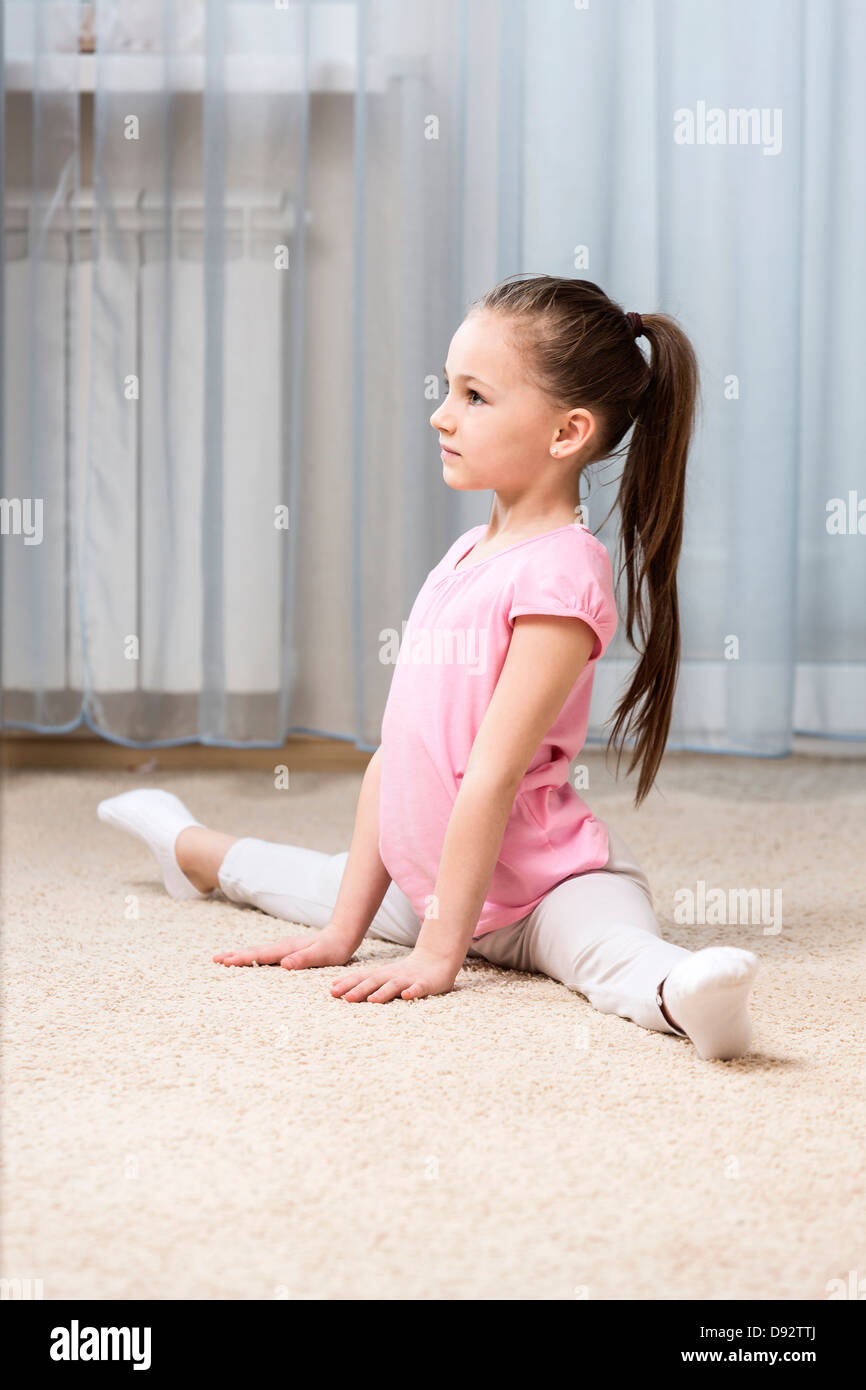 Ballerina Mädchen tun die Splits in ihrem Schlafzimmer Stockfoto