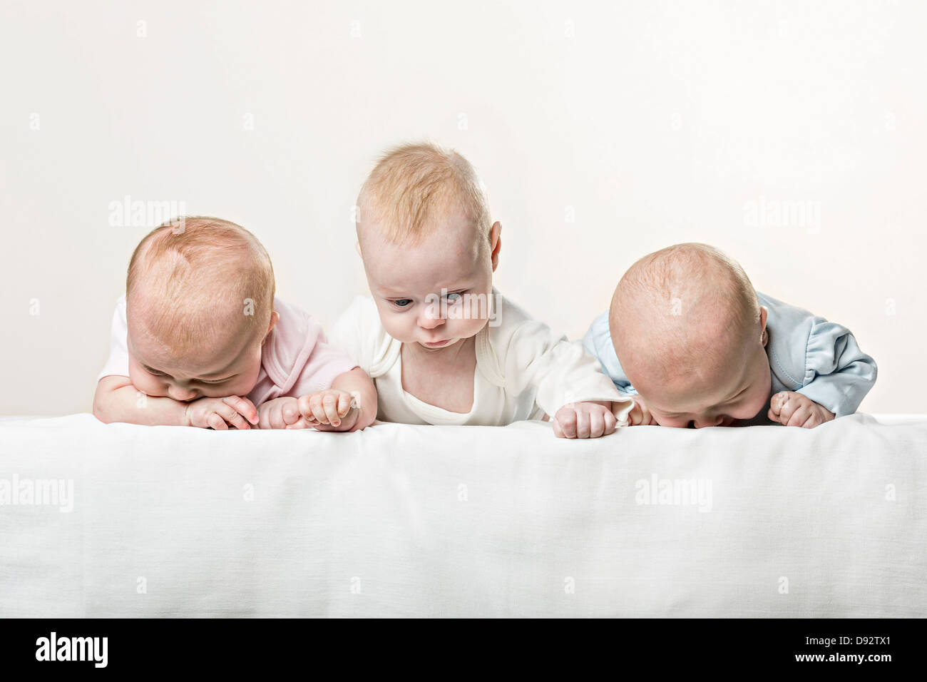 Drei Babys in Folge lustige Grimassen Stockfoto