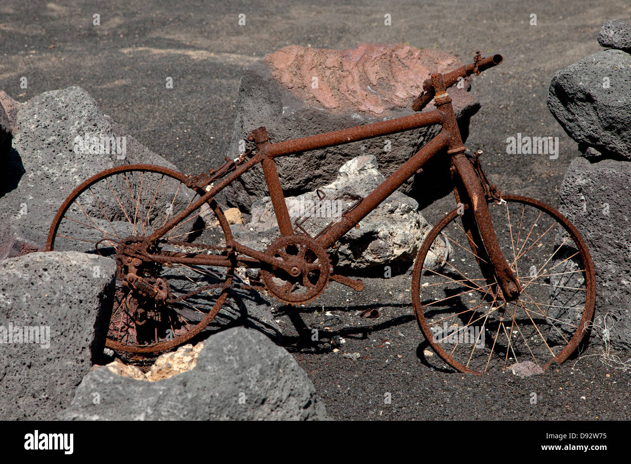 Rostigen Fahrrad unter Felsbrocken Stockfoto