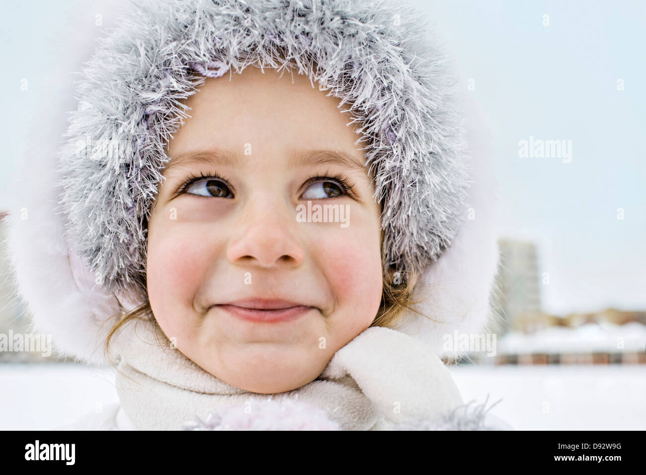 Verschmitzt lächelnd junges Mädchen trägt einen Pelzhut im Freien im winter Stockfoto