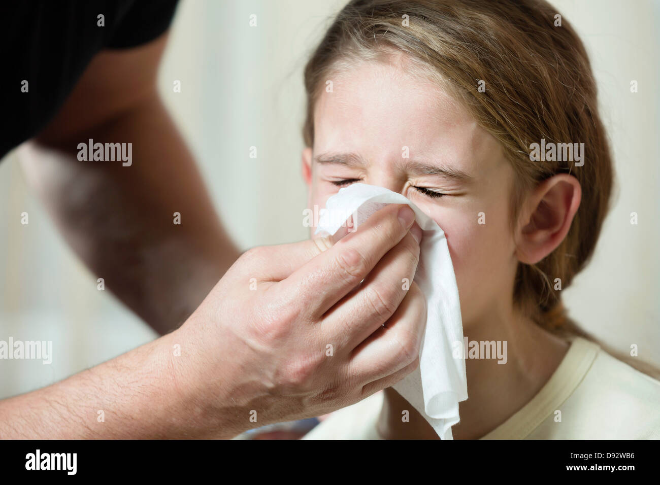 Vater wischte Tochter Nase mit Gewebe Stockfoto