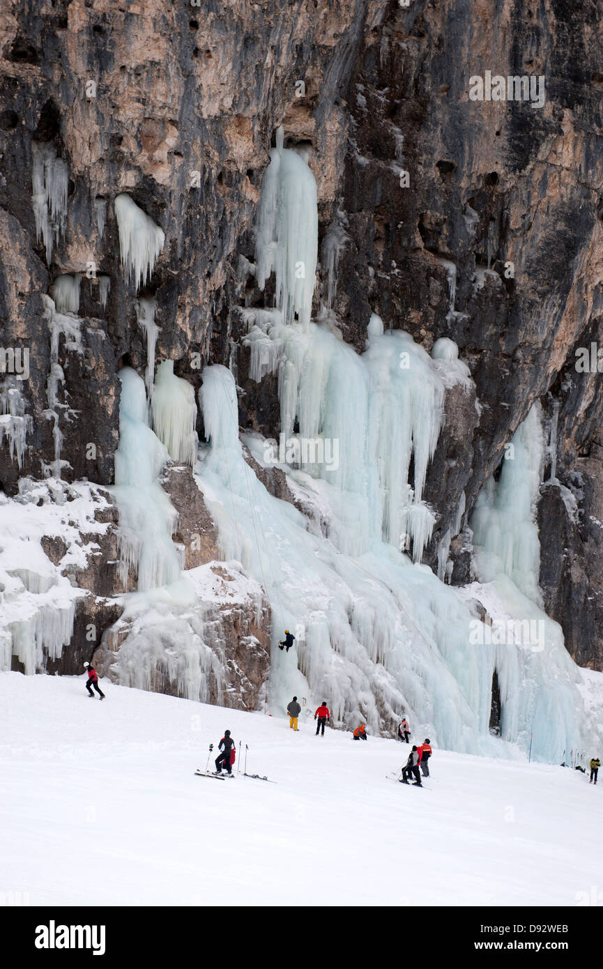 Skifahrer beobachten Eiskletterer auf Felswand am Lagazuoi, Südtirol, Italien Stockfoto