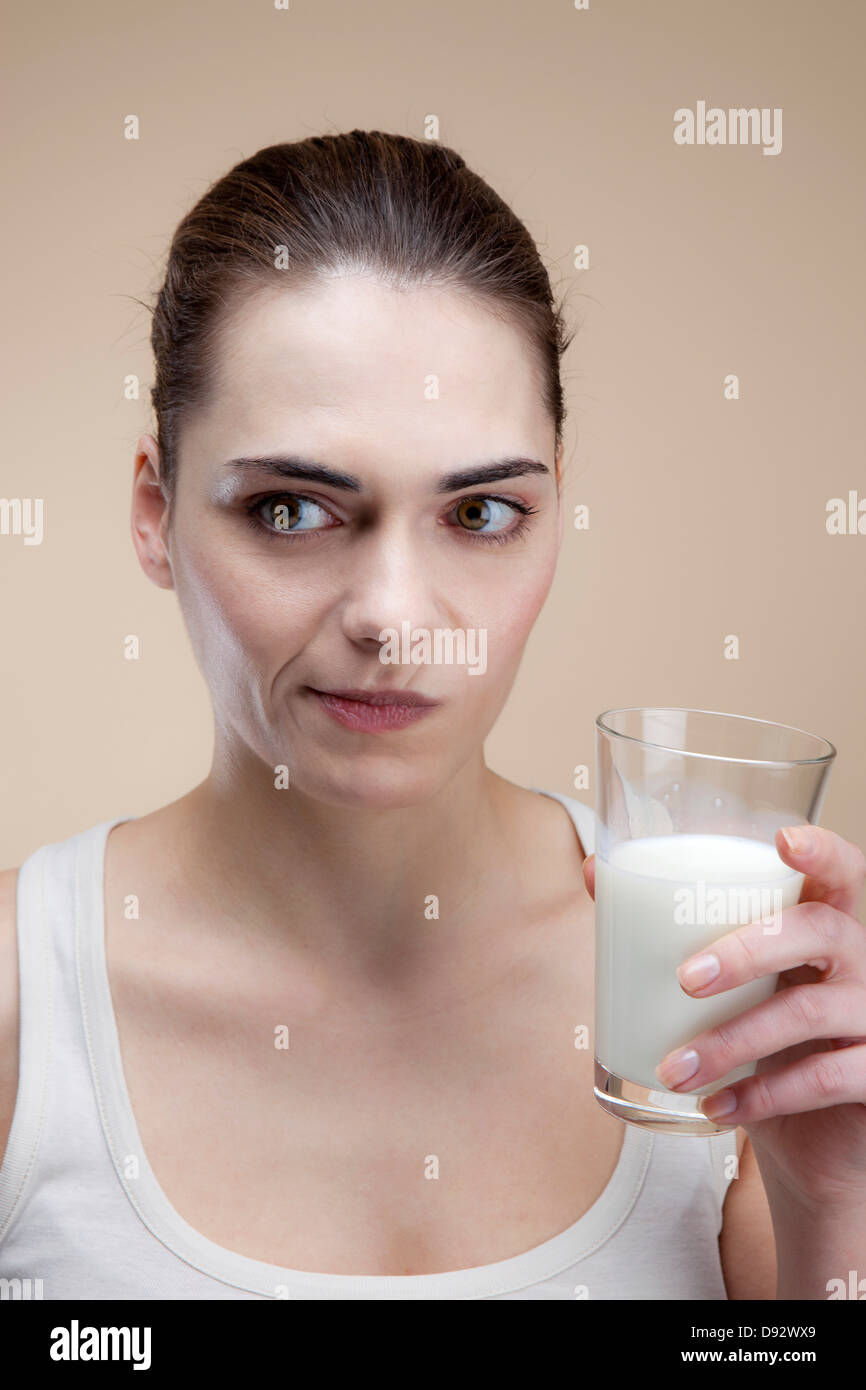 Eine junge Frau, die nach der Einnahme eines Schluck Milch Grimasse Stockfoto