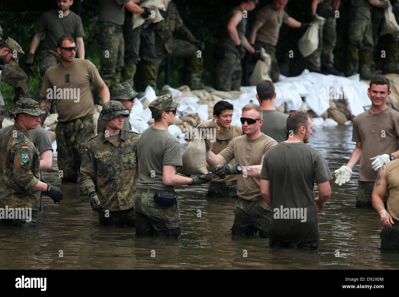 Soldaten der Bundeswehr bauen einen Damm durch die Anhäufung von Sandsäcken in einer Straße, die vom Wasser der Elbe in Magdeburg, Deutschland, 9. Juni 2013 überflutet. Die Hochwassersituation herrscht in den Bereichen an der Elbe. Foto: Jens Büttner Stockfoto