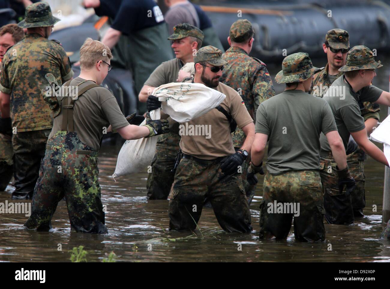 Soldaten der Bundeswehr bauen einen Damm durch die Anhäufung von Sandsäcken in einer Straße, die vom Wasser der Elbe in Magdeburg, Deutschland, 9. Juni 2013 überflutet. Die Hochwassersituation herrscht in den Bereichen an der Elbe. Foto: Jens Büttner Stockfoto