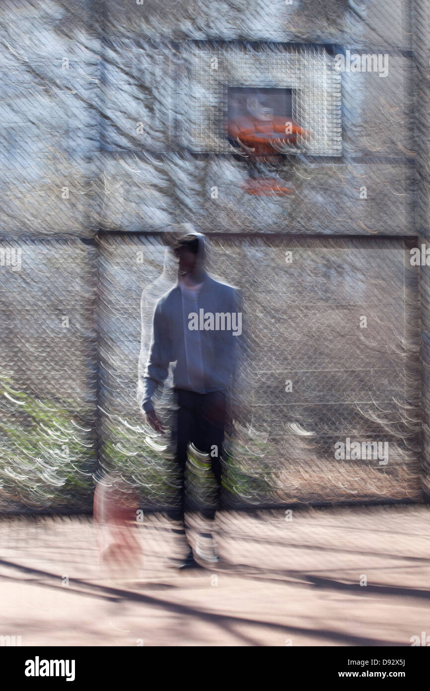 Ein hip junger Mann dribbling einen Basketball auf einem öffentlichen Freiplatz Stockfoto