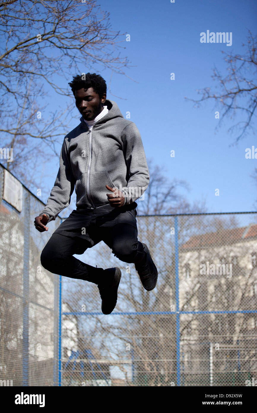 Ein ernst junger Mann springt hoch in der Luft, Berlin, Deutschland Stockfoto