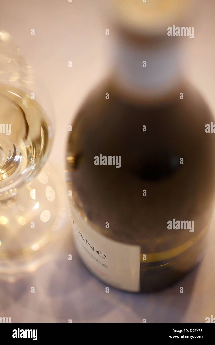 Detail einer Flasche Weißwein und ein Glas Wein Stockfoto