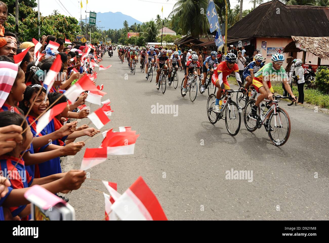 Padang, Indonesien - 9. Juni: Grundschule Kinder von Padang Regency unterstützt den Fahrer mit indonesischen Flagge während der Etappe 7 Tour de Singkarak 2013.   (Foto von Robertus Pudyanto/AFLO) Stockfoto