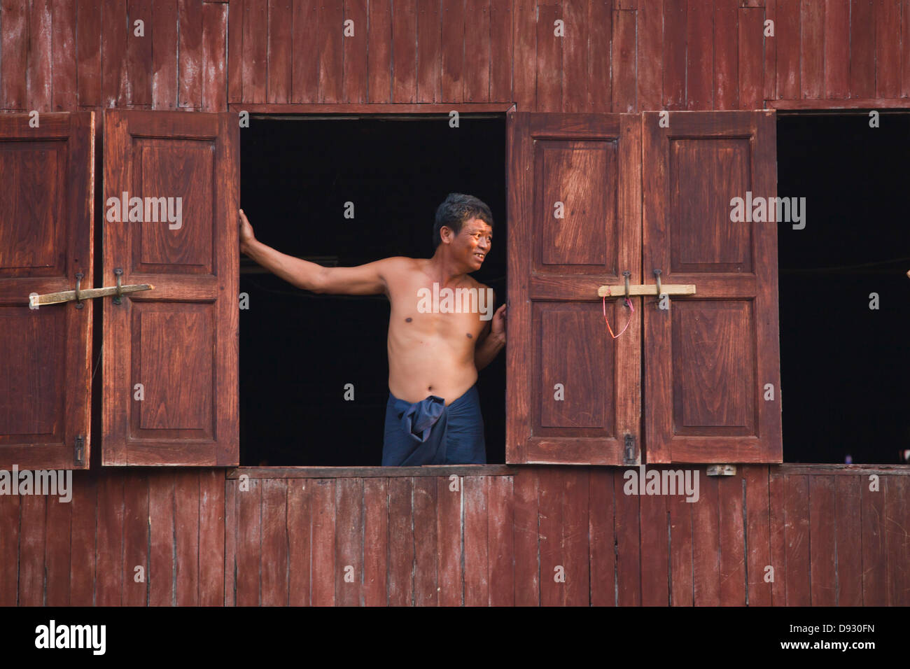 Ein Mann in das Fenster seines Hauses im Dorf des PWE SAR KONE - INLE-See, MYANMAR Stockfoto