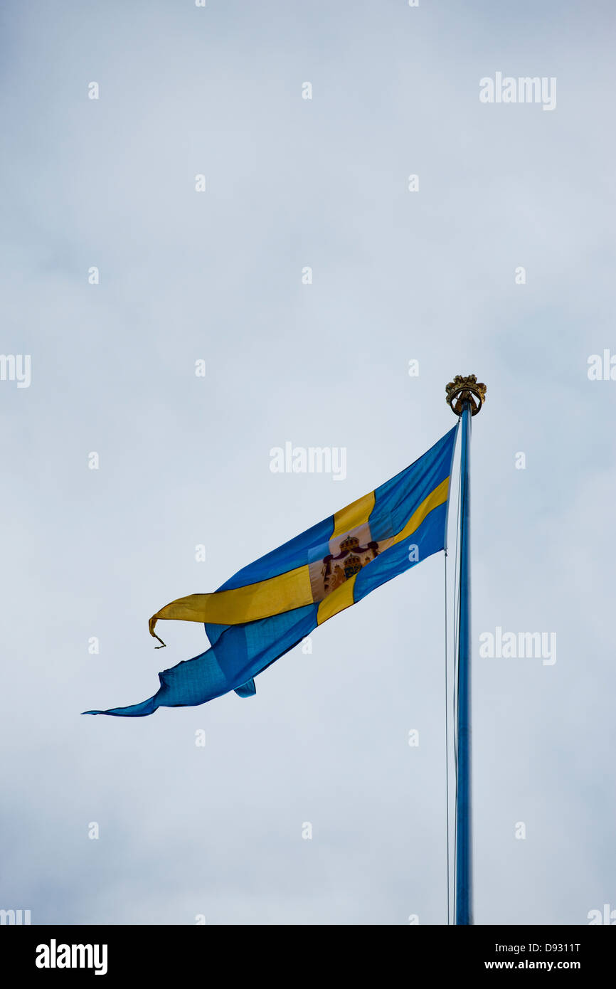 Schwedische Flagge gegen bewölktem Himmel Stockfoto