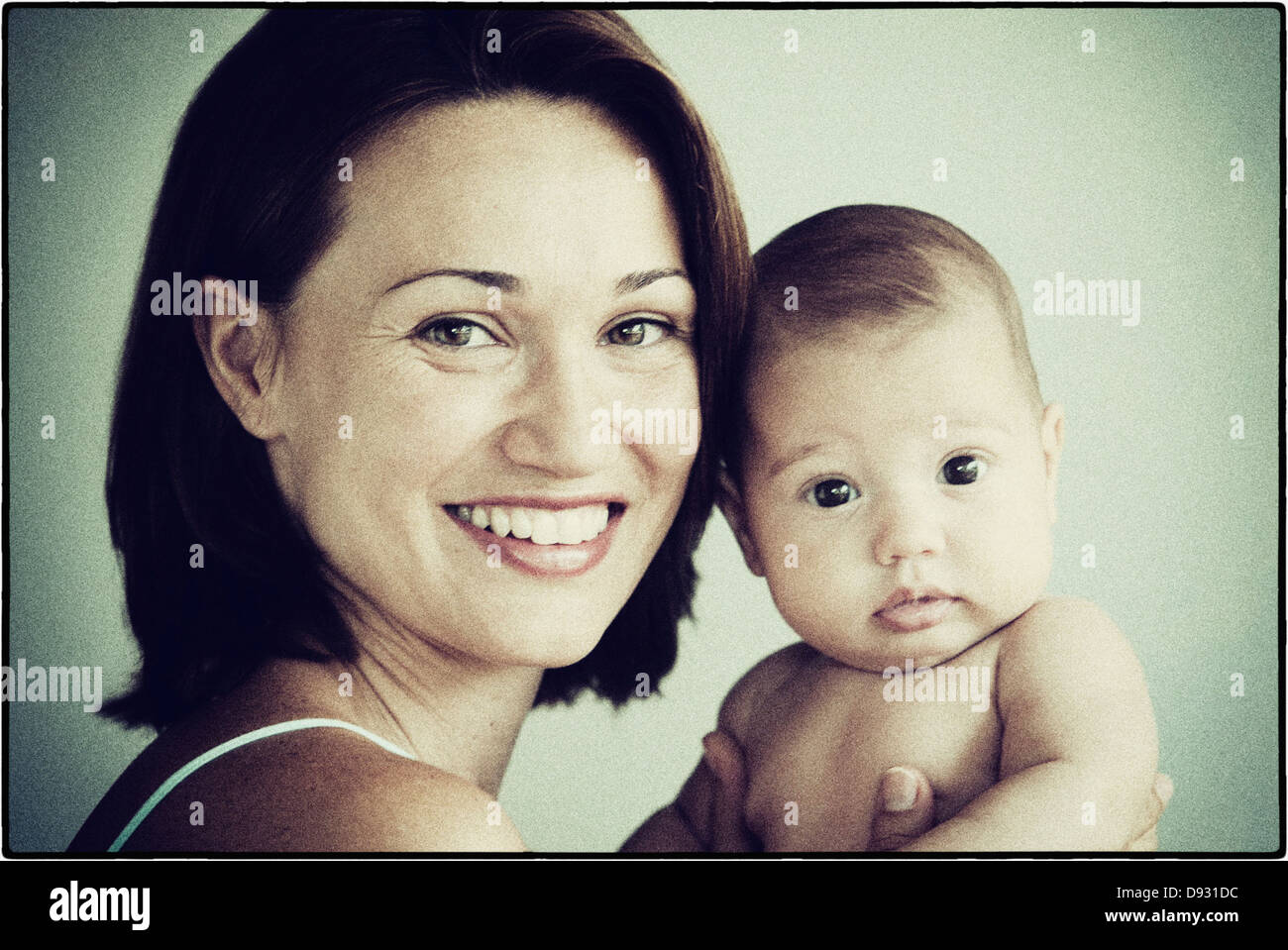 Hispanische Mutter halten baby - Smartphone-aufgenommenes Stockfoto