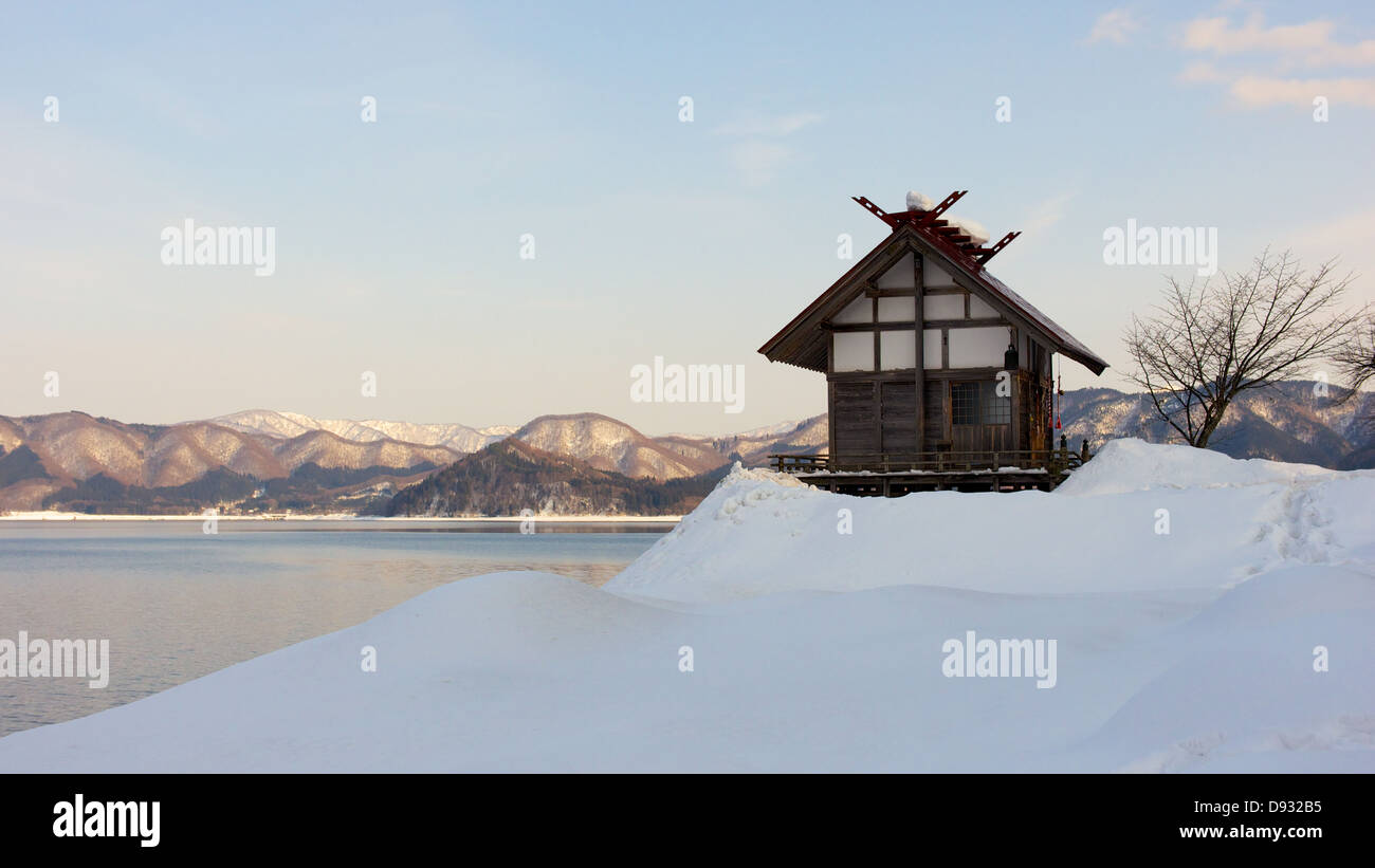 Kleinen Shinto-Schrein durch die Gewässer See Tazawa bedeckt im Winter Schnee Stockfoto