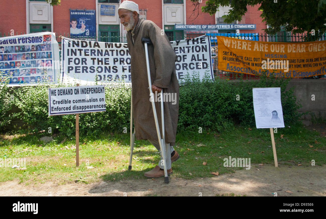 Srinagar, indisch verwalteten Teil Kaschmirs 10. Juni 2013: eine ältere Kashmiri muslimischen Verwandten des Menschen einer vermissten Person neben einem Banner bei einem monatlichen Sit-in Protest gegen steht erzwungen verschwinden in Srinagar, der Sommer Kapital Stadt von indisch verwalteten Teil Kaschmirs. Gruppen der menschlichen Rechte, einschließlich der Verein der Eltern der vermissten, sagen, dass mehr als 10.000 Kaschmiris durch indische Regierungskräfte in den vergangenen 22 Jahren fehlten.  (Sofi Suhail / Alamy Live News) Stockfoto