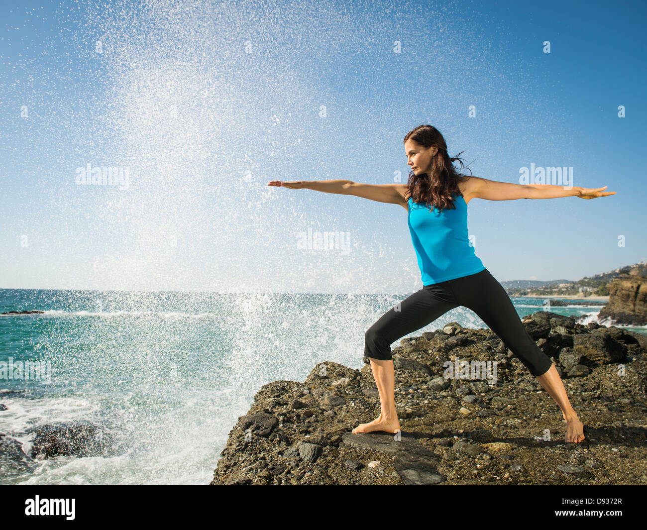 Gemischte Rassen Frau praktizieren Yoga auf felsigen Strand Stockfoto