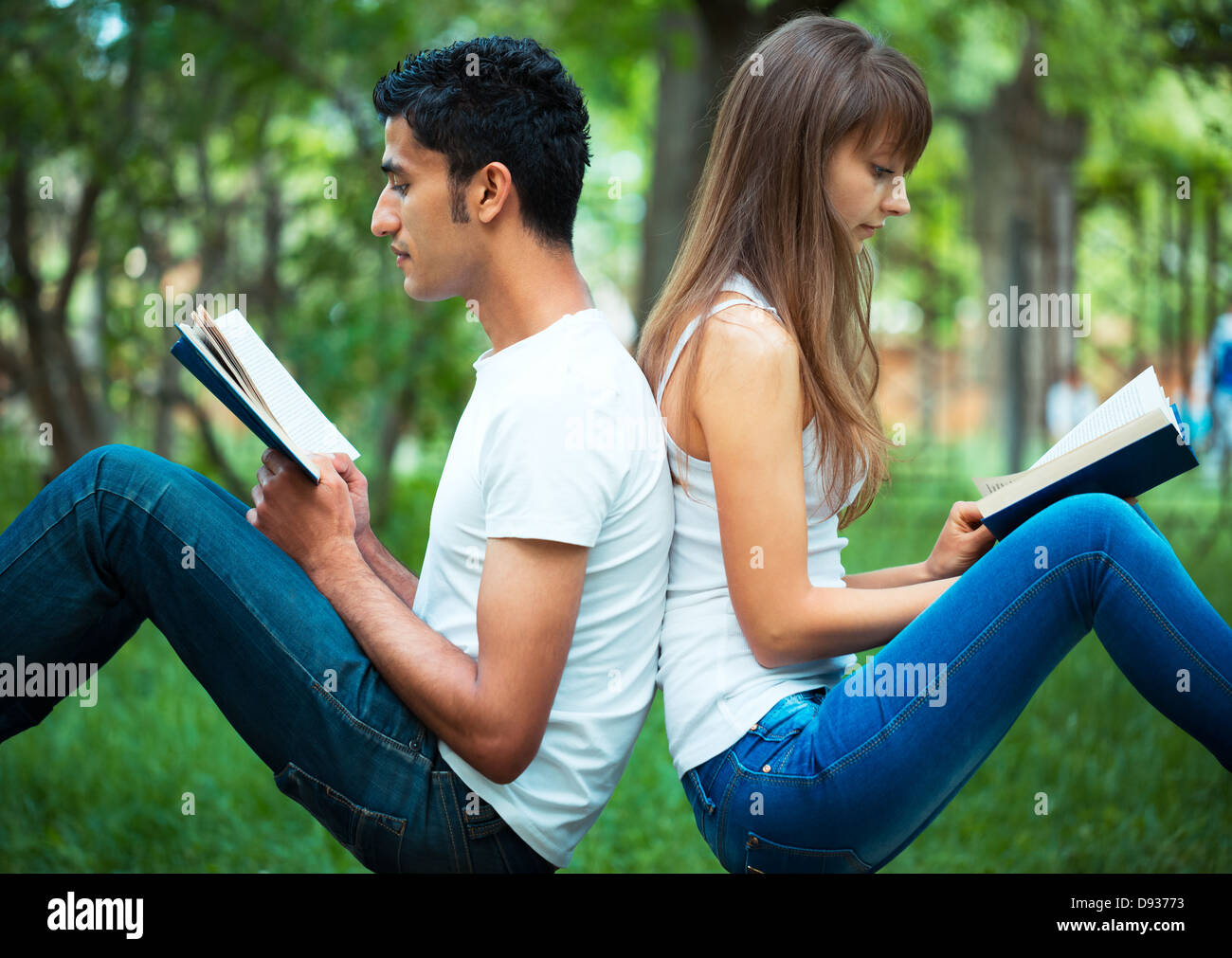 Der Mann mit den Mädchen Studenten zurück zu einem Buch im Park im freien Stockfoto
