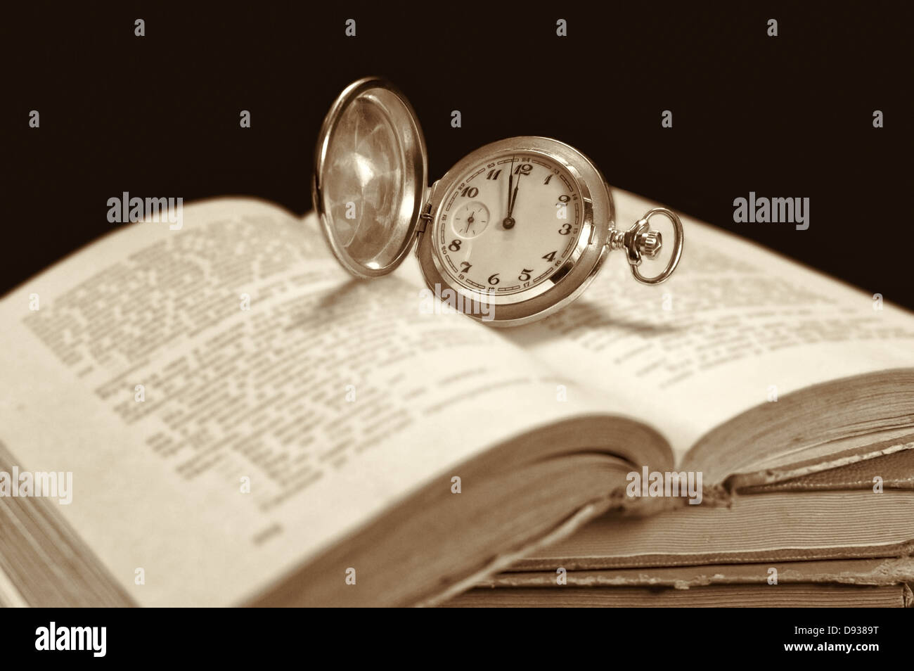 Alte Taschenuhr auf offenes Buch. Selektiven Fokus auf Uhr. Stockfoto