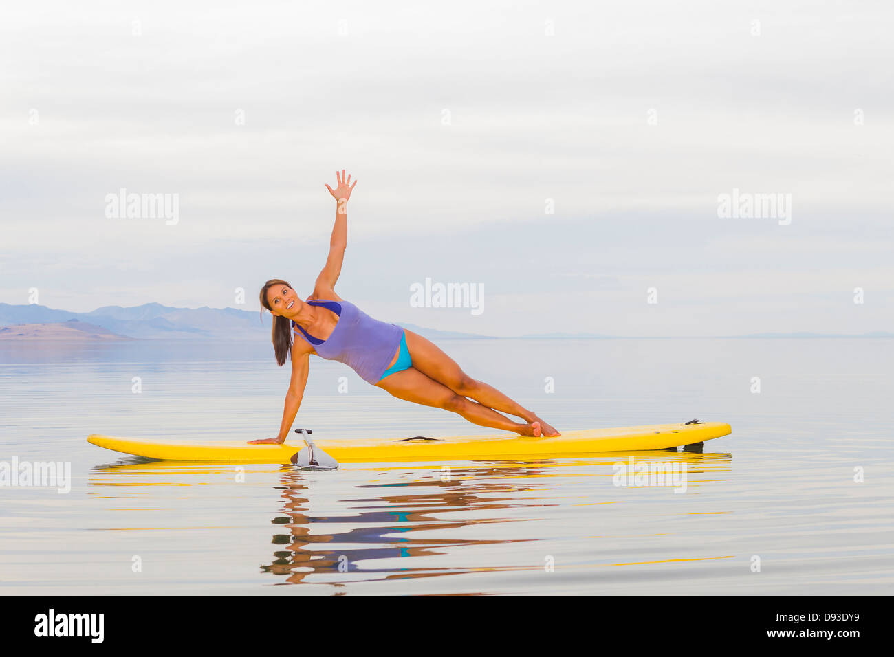 Philippinische Frau praktizieren Yoga auf Paddel board Stockfoto