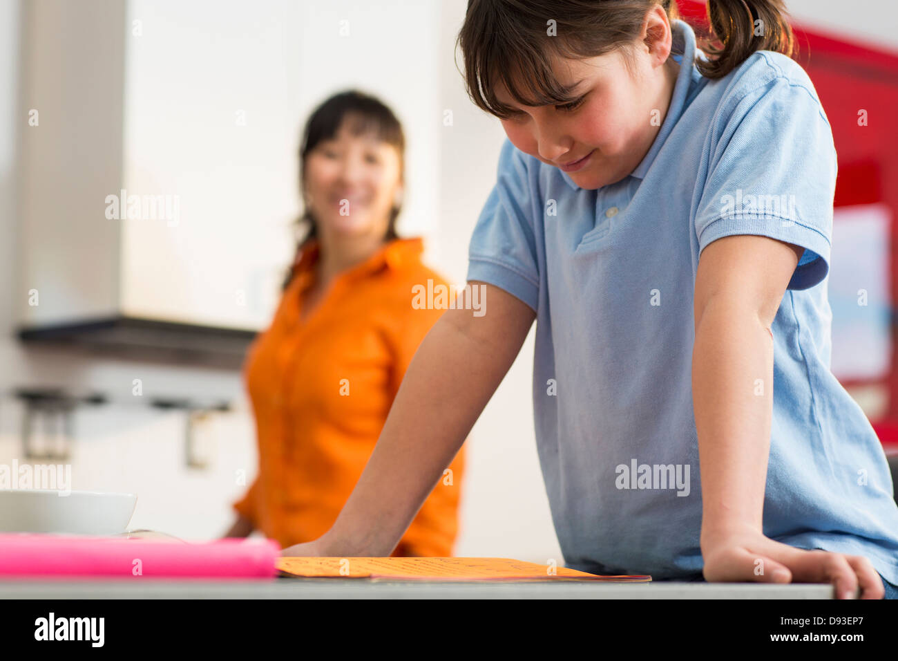 Mädchen lesen Hausaufgaben am Schreibtisch Stockfoto