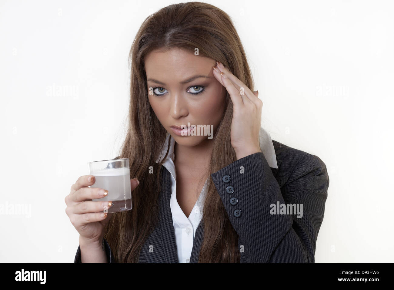 Business-Frau in einem Anzug mit starke Kopfschmerzen trinken Medizin in der Hoffnung es wird verschwinden und machen sie sich besser fühlen Stockfoto