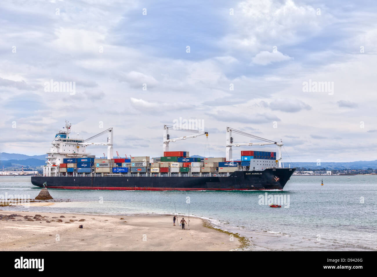 Das Containerschiff "San Aurelio" verlässt den Hafen von Tauranga in der Bucht von viel Region Neuseelands. Der Tiefe... Stockfoto