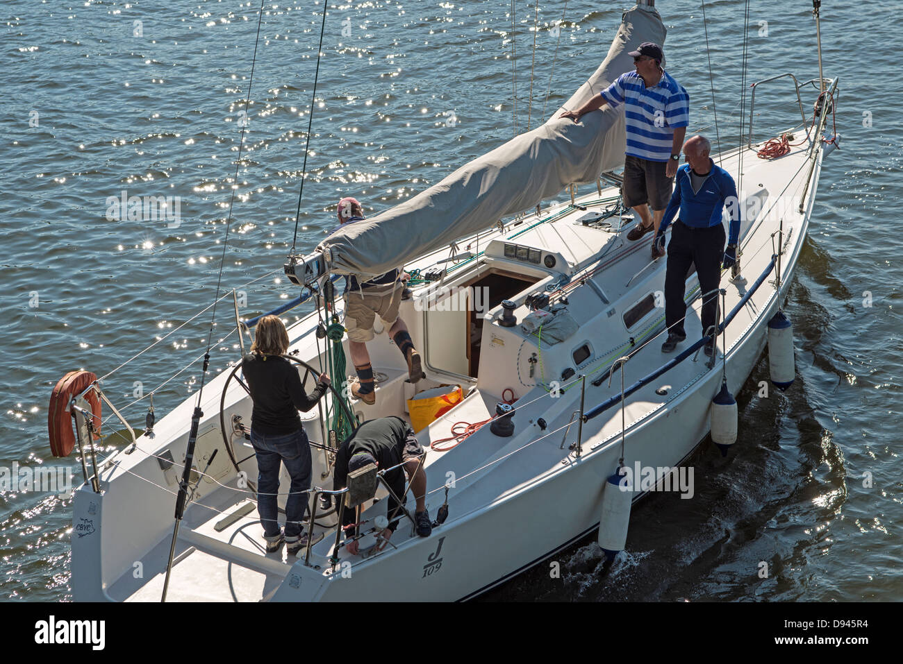 Eine Yacht und seine Crew als es fotografiert unterquert die Klappbrücke an der Cardiff Bay Staustufe in Cardiff Bay Stockfoto