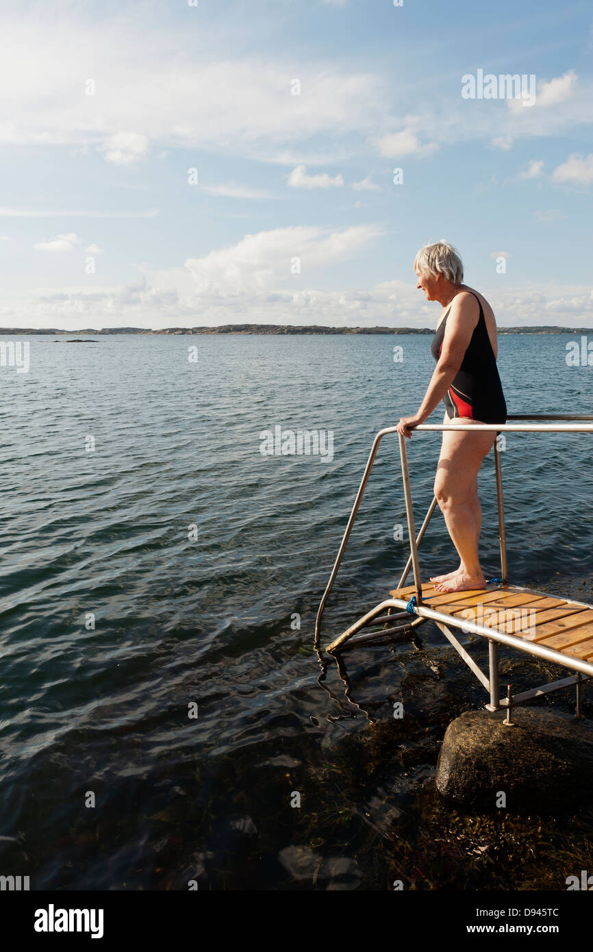 Ältere Frau nur schwimmen, Leiter Stockfoto