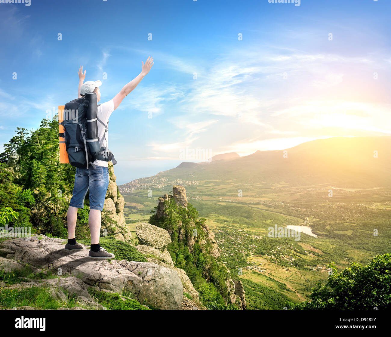 Tourist mit Rucksack genießen Talblick vom Gipfel eines Berges Stockfoto