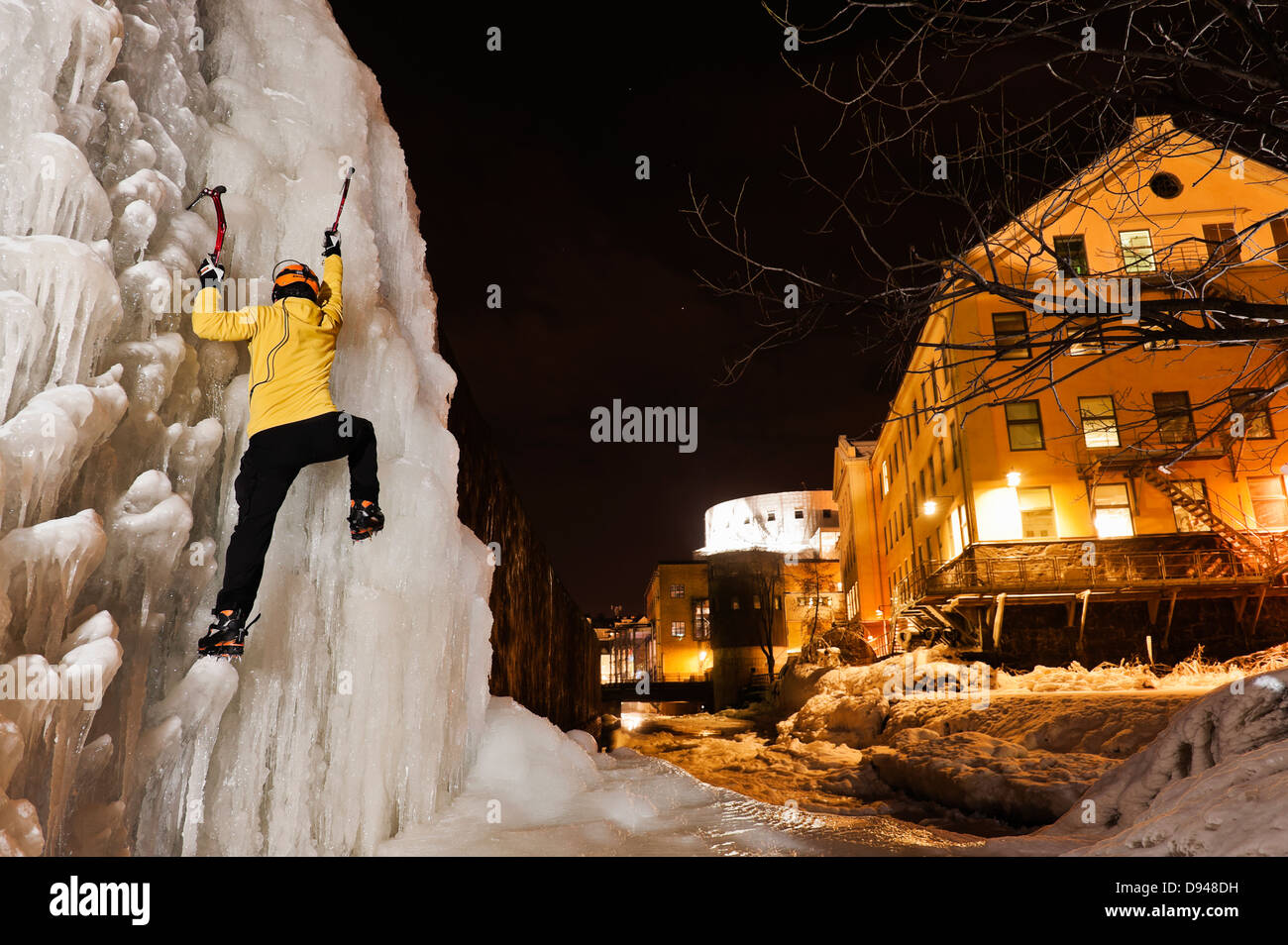 Mann-Eisklettern auf gefrorenen Wasserfall im Stadtgebiet Stockfoto