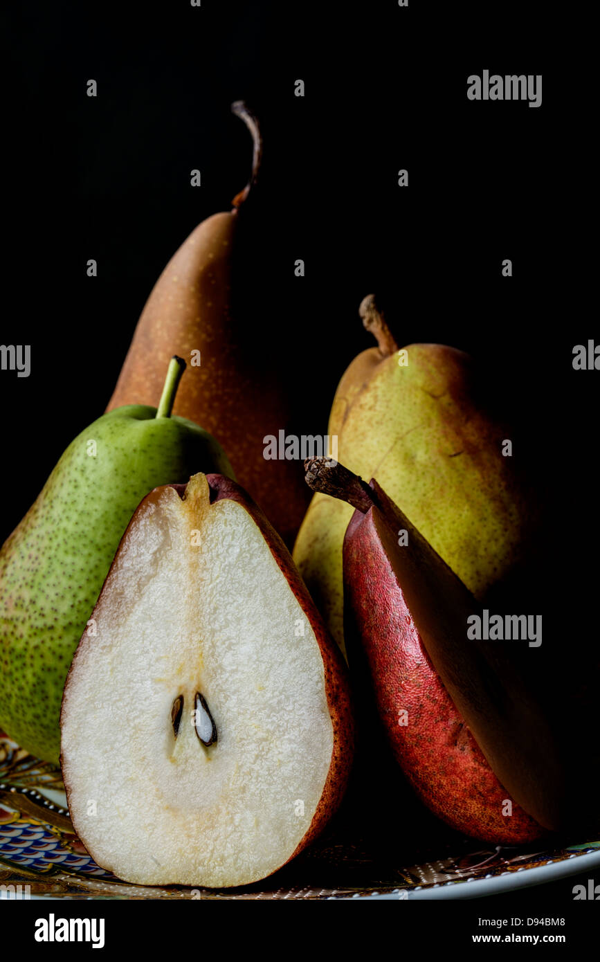 Obstteller mit Birnen auf schwarzem Hintergrund Stockfoto