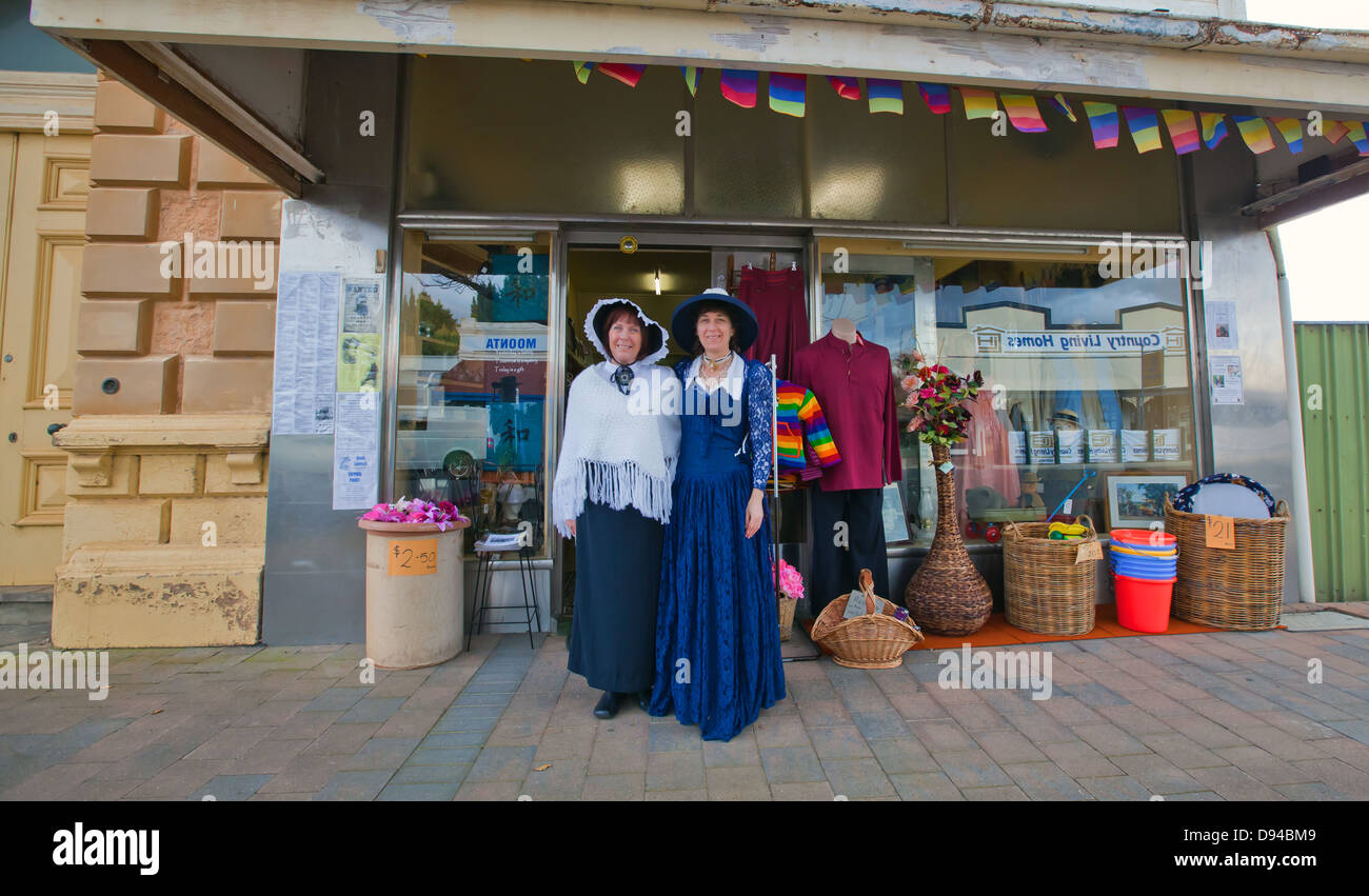 2 Frauen in der ländlichen Gemeinde Moonta auf Yorke Peninsula in historischer Kleidung außerhalb einer Ladenfront gekleidet Stockfoto