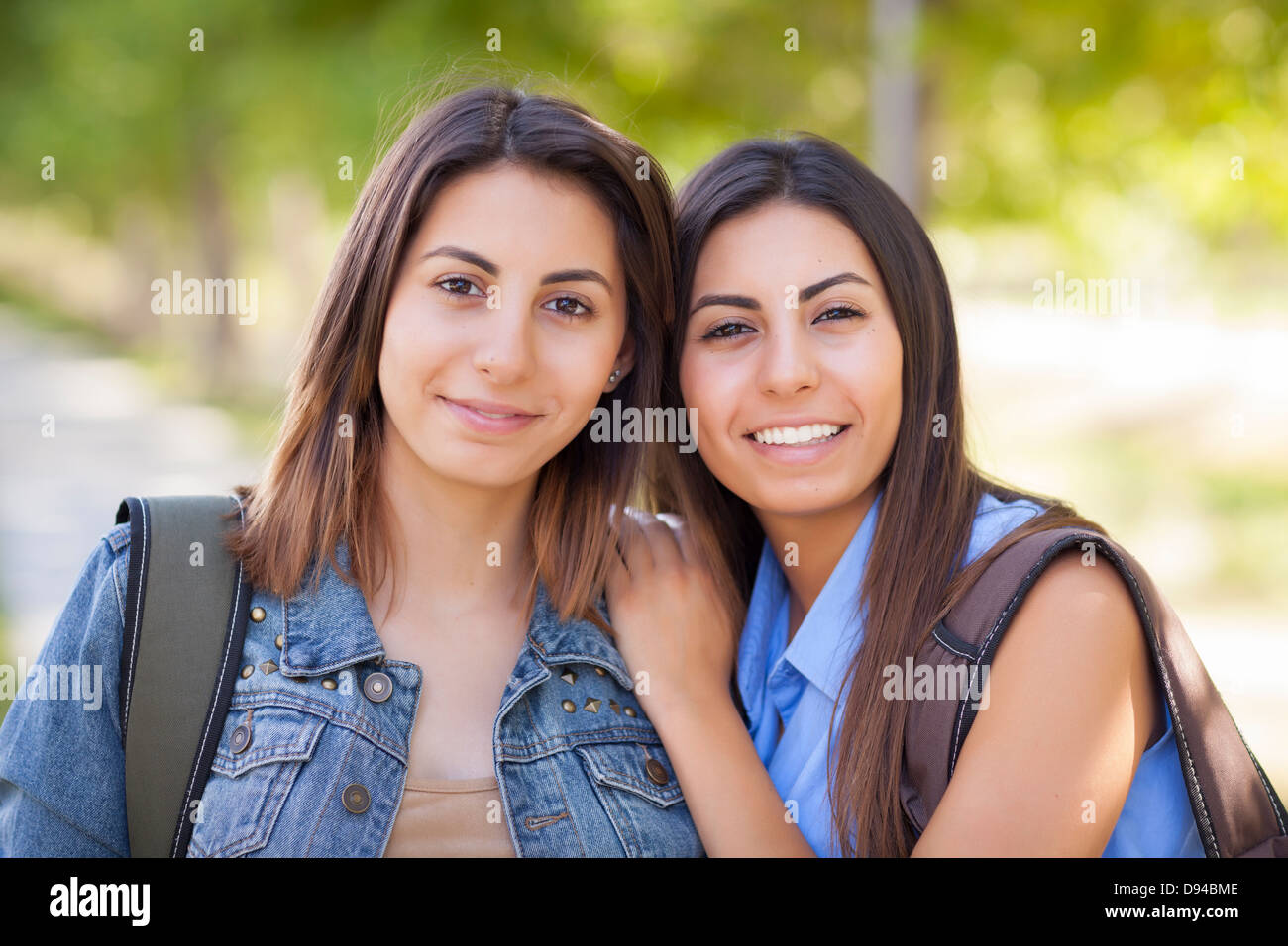 Junge Erwachsene Mischlinge Twin Sisters Portrait tragen Rucksäcke außerhalb. Stockfoto