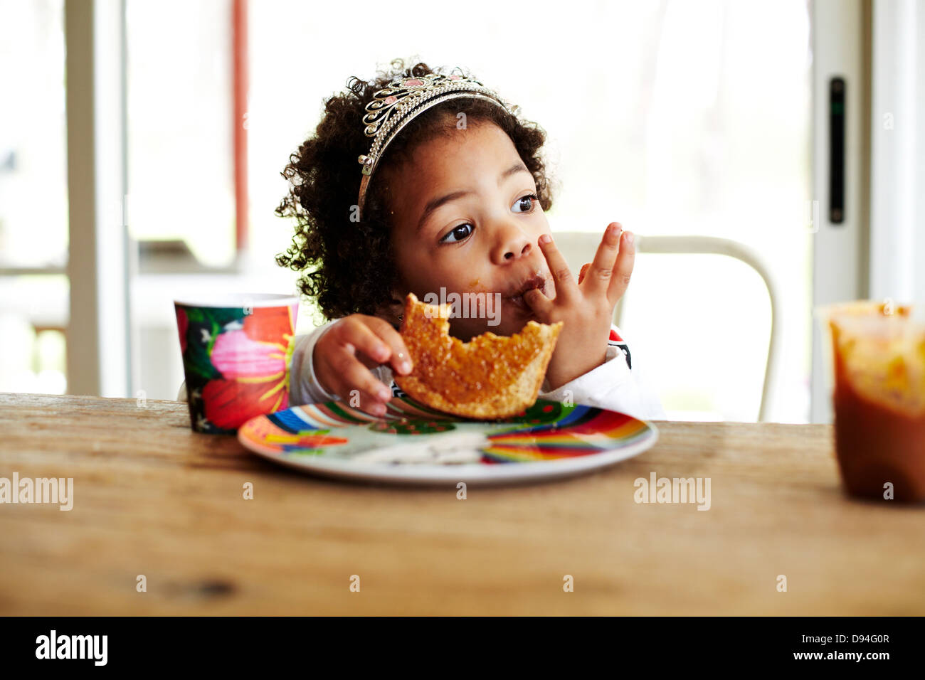 Gemischte Rassen Mädchen Essen am Tisch Stockfoto